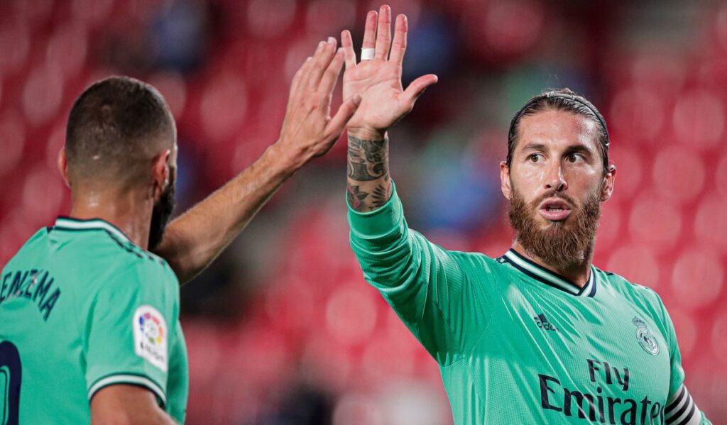Ramos wearing Real Madrid's shirt high-fiving Benzema