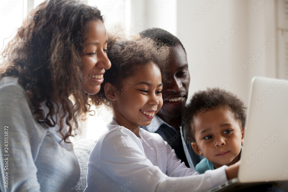 A happy Black family using online technonlogy. Photo Credit- AdobeStock
