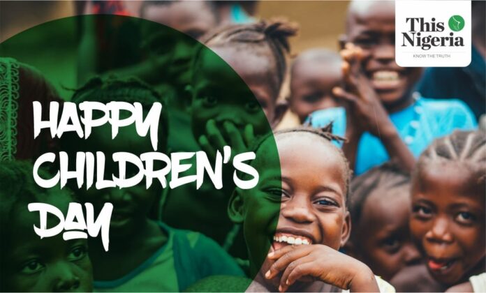 Children’s Day: Protecting the Nigerian child from the dangers of online technology Nigerian children happy as they get a camera shot. An inscription of Happy CHildren's Day is on the picture with a 'This Day' logo.
