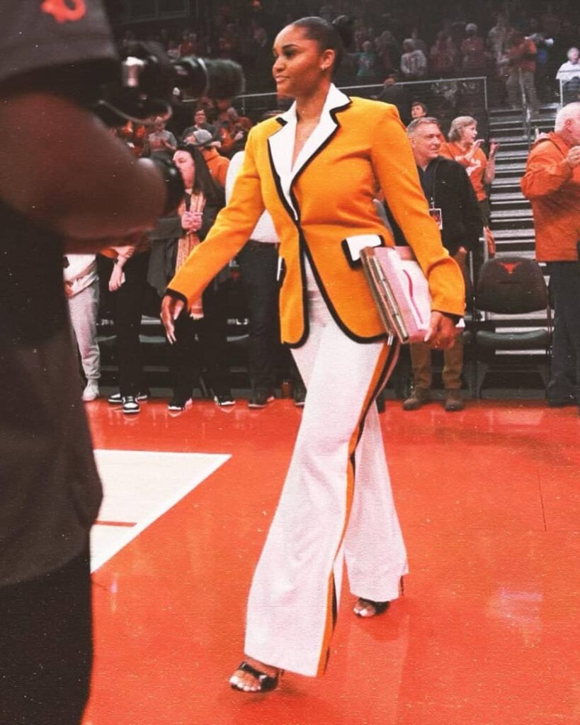 Carter in an orange, black and white stripped pant suit.
Credit:- Sydney Carter|Instagram