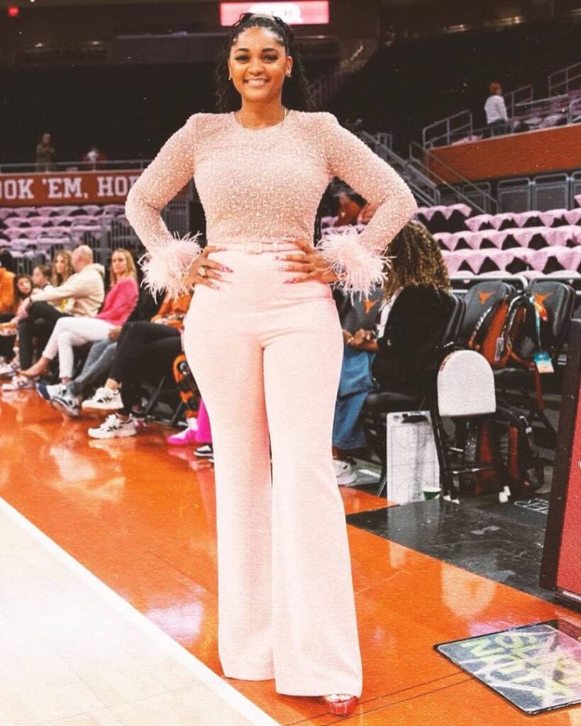 The retired basketball player in a peach pants and a beaded lace top with feather at the hem of the sleeves 
Credit:- Sydney Carter|Instagram