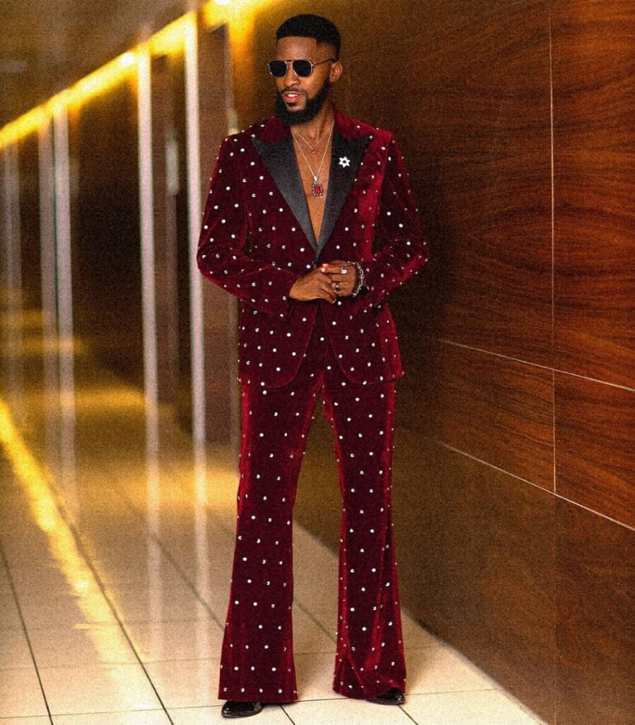 Akin Faminu in a red velvet tuxedo adorned with Swarovski crystals.