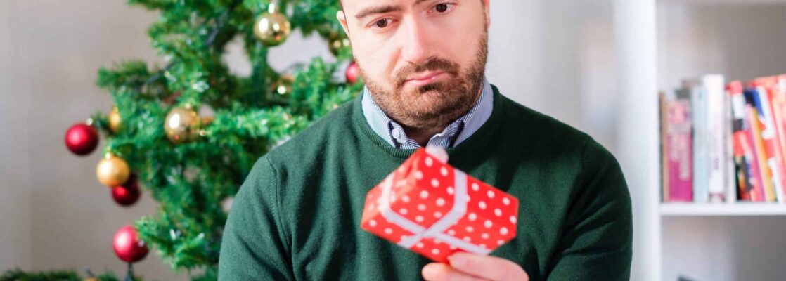 A man staring at a gift from his partner. Credit: iStock