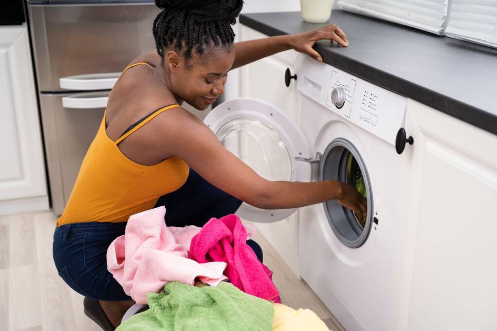 A woman using a washing machine/home appliance